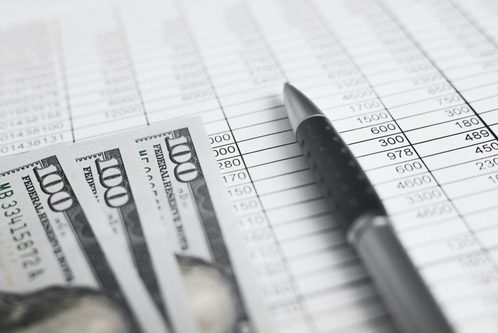 Money, accounting documents invoices and a pen. Close-up, low angle view, selective focus